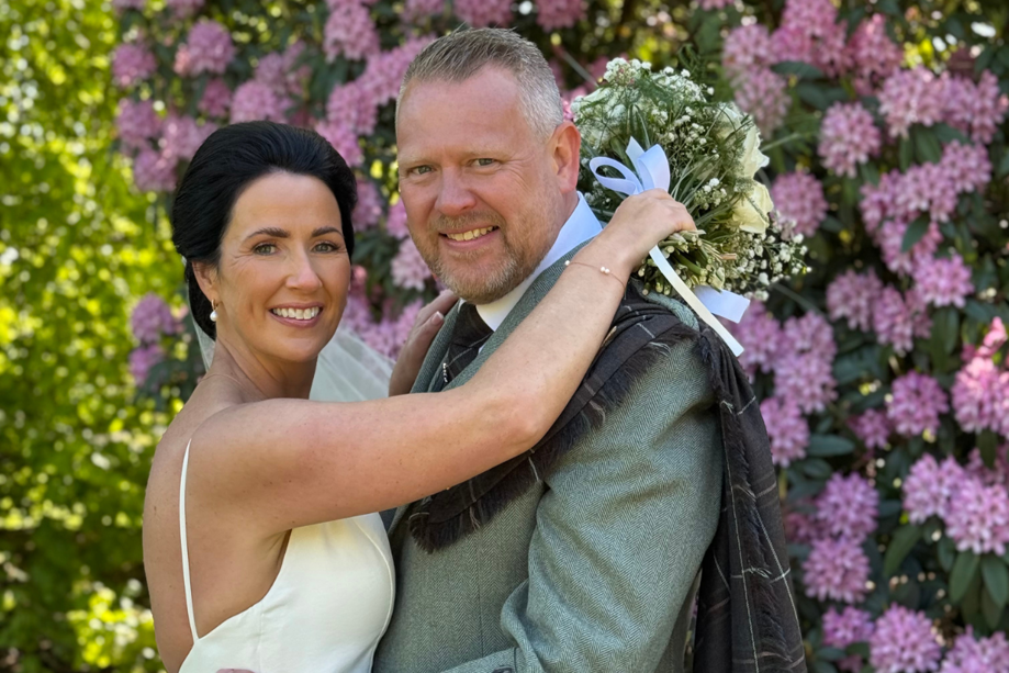 Wedding couple smiling at camera by Let's Do It Creative